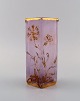 Daum Nancy, France. Art nouveau vase in pink mouth-blown art glass with 
hand-painted flowers and gold decoration. Early 20th century.
