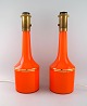 Anders Pehrson for Ateljé Lyktan. Two large table lamps in orange mouth-blown 
art glass with gold decoration. 1960s.

