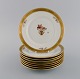 Eight Royal Copenhagen Golden Basket lunch plates in hand-painted porcelain with 
flowers and gold decoration. 1960s. Model number 595/9528.
