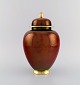 Carlton Ware, England. Large Rouge Royale lidded vase in hand-painted porcelain. 
Beautiful luster glaze. Gold decoration on edges and lid knob. 1930s.
