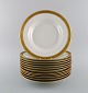 Royal Copenhagen service no. 607. Twelve deep porcelain plates. Gold border with 
foliage. Model number 607/9587. Dated 1944.
