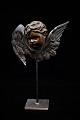 K&Co. presents: Decorative, antique angel head with face in bronze and wings in copper mounted on a metal foot...