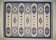 Swedish handwoven wool rug with fringes in the "Rölakan" technique.Geometric shapes in light blue, dark blue, and pink on a white background.