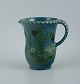 Kähler jug &#8203;&#8203;in glazed ceramic. 
Decorated with flowers on a blue background.