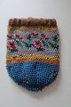 Antique little Handmade/purse/bag, made of beads
This beautiful old handmade bag/purse, from about the end of the 1800-years, is 
handmade of beads with embroidery which shows flowers/roses
The shape is with a possibility for cords at the top