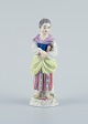 Meissen, Tyskland, porcelænsfigur. Overglasur.
Ung kvinde med bog.