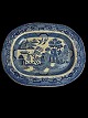 Antique faience serving dish with Chinese pattern. 
The pattern is called Blue Willow. Presumably 
English, Staffordshire. Indistinctly marked.