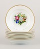 Bing & Grøndahl, eight deep plates in porcelain hand-painted with polychrome 
flowers and gold decoration.