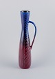 Carl Harry Stålhane for Rörstrand. Tall and slim ceramic pitcher in blue and 
burgundy tones.