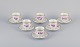Bing & Grøndahl, Denmark. A set of six coffee cups and saucers with flower 
decorations in purple and gold trim. Hand-painted.