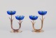 Gunnar Ander for Ystad Metall, Sweden.
A pair of two-armed candle holders in brass and blue art glass shaped like 
flowers.