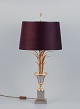 In the style of Maison Jansen. Large table lamp in brass with a base in the 
shape of palm leaves and a textile shade.