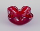 Murano, Italy. Art glass bowl in deep red glass with air bubbles inside.