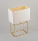 Designer table 
lamp in brass 
with a white 
fabric shade. 
...