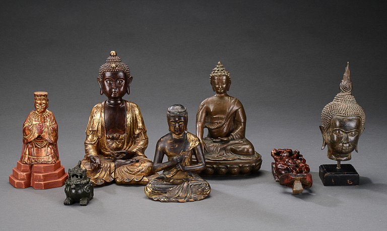 A collection of oriental figures in bronze and wood in form of Buddhas, foo dog 
etc.