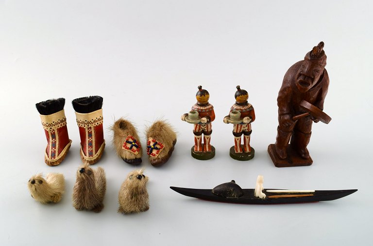 A selection of Greenlandic artefacts, comprising, three wooden figures, a wood 
and bone kayak model, two pairs of doll