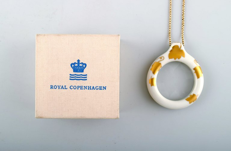 Rare Royal Copenhagen magnifying glass, porcelain decorated with leaves in gold. 
In original box.