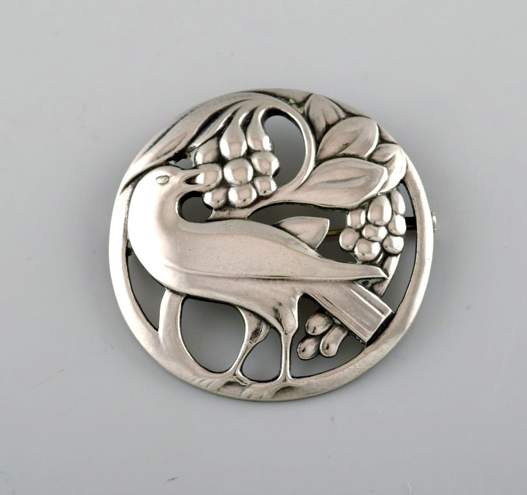 Tidlig Georg Jensen broche i sterlingsølv. Designnummer 53. Fuglemotiv og 
drueklase.