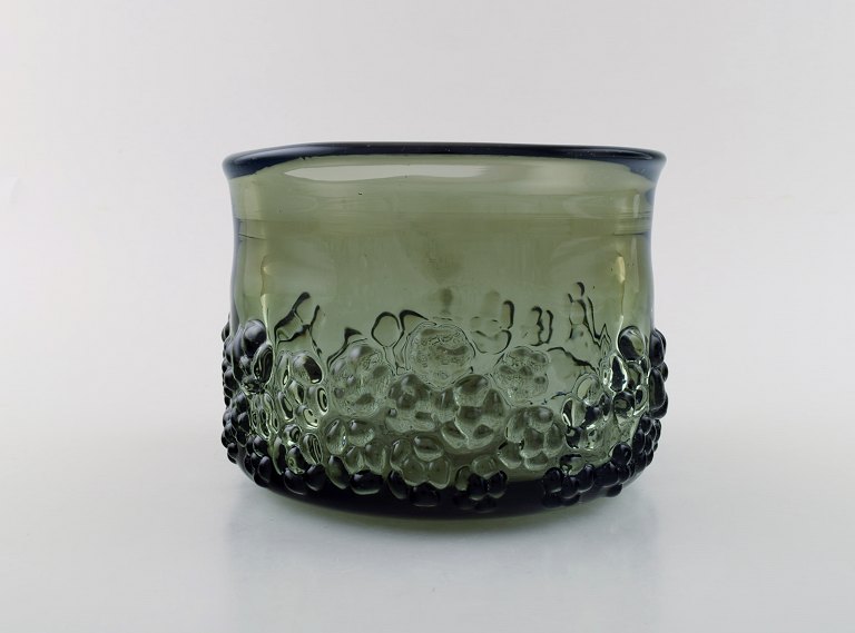 Finnish glass artist. Large organic bowl in green mouth blown art glass. Flowers 
in relief. 1970