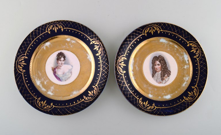 To dekorationstallerkener i håndmalet porcelæn med gulddekoration. Motiver af 
Louis XIV og Madame Récamier. Wien, ca 1900.
