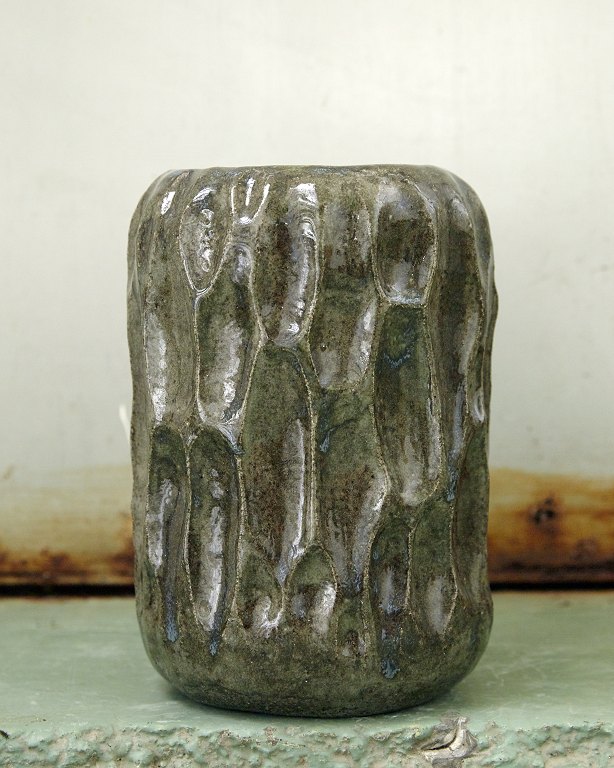 Christina Muff, Danish contemporary ceramicist (b. 1971). Medium sized vase made 
from dark grey stoneware clay with carved areas.
Clear, shiny glaze with hints of blue like minerals in soil.