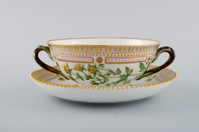 Royal Copenhagen Flora Danica boullionkop med underkop i håndmalet porcelæn med 
grenformede hanke, blomster og gulddekoration. Modelnummer 20/3612.  
