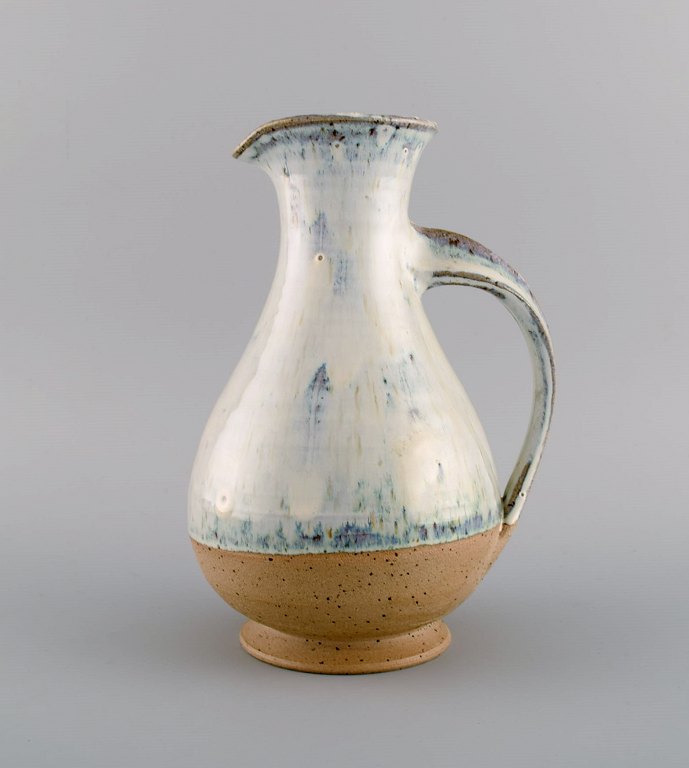 Gutte Eriksen style. Jug in glazed ceramics with turned handle. Raku-burnt 
technique. 1980s.
