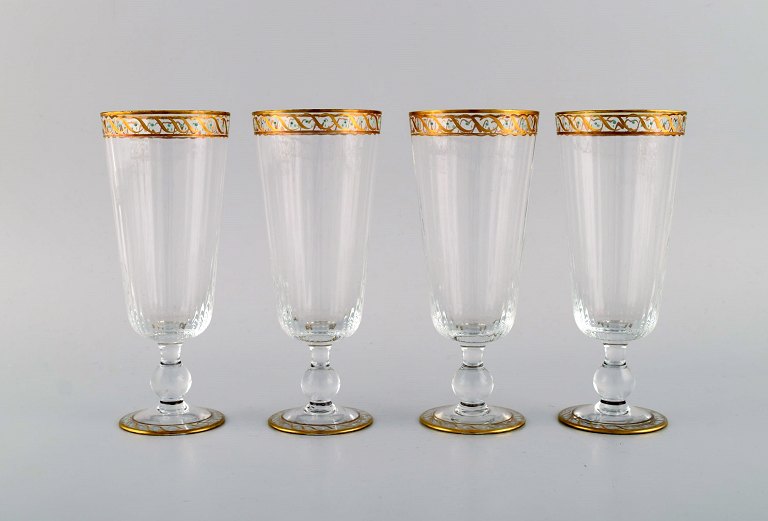 Nason & Moretti, Murano. Four champagne flutes in mouth-blown art glass with 
hand-painted turquoise and gold decoration. 1930s.
