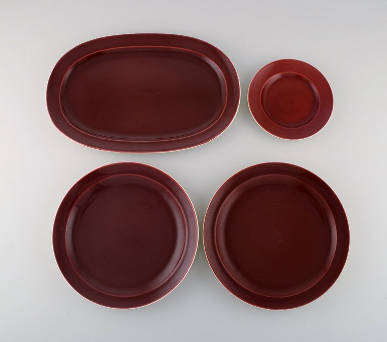 Royal Copenhagen / Aluminia Confetti plate and three large dishes in burgundy 
red glazed faience. Mid-20th century.
