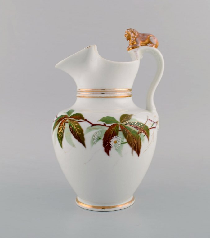 Antik Bing & Grøndahl chokoladekande i porcelæn modeleret med løve på hanken. 
Håndmalede blomster og gulddekoration. 1870