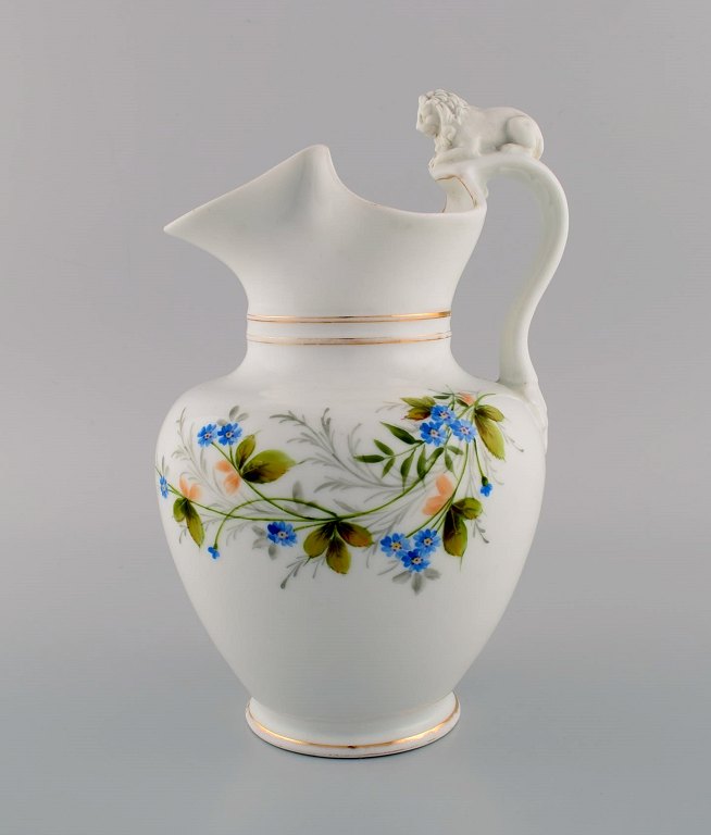 Antique Bing & Grøndahl chocolate jug in porcelain modeled with a lion on the 
handle. Hand-painted flowers and gold decoration. 1870s.
