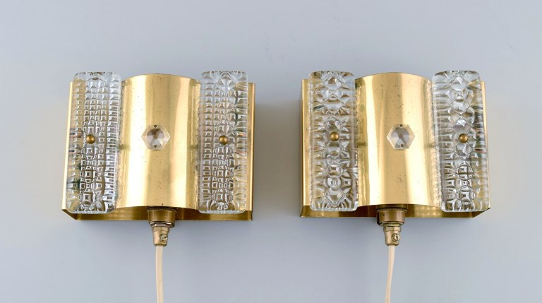 A pair of wall lamps made of brass and art glass. Danish design, 1970s.
