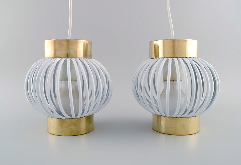 Two designer pendants in brass and white plastic. 1960s / 70s.
