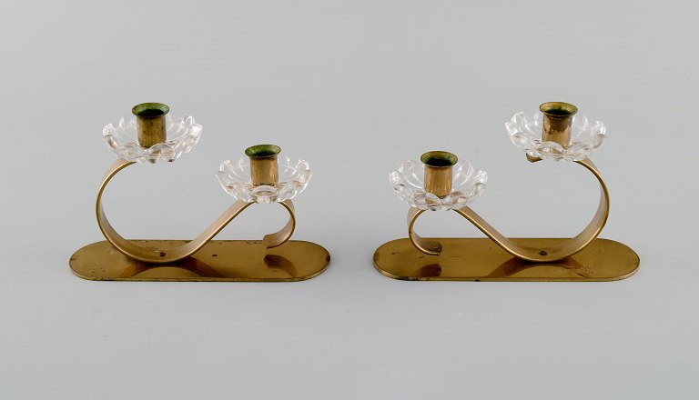 Gunnar Ander for Ystad Metall. Two candlesticks in brass and clear art glass 
shaped like flowers. 1950s.
