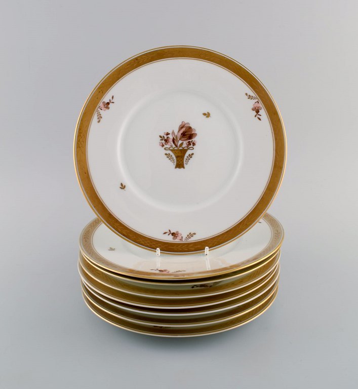Eight Royal Copenhagen Golden Basket plates in porcelain with flowers and gold 
decoration. Model number 595/10520.
