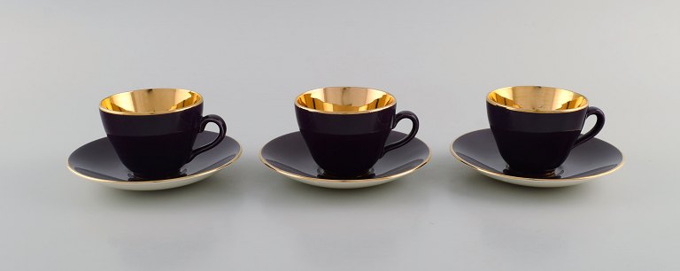 Three Royal Copenhagen / Aluminia Confetti mocha cups with saucers in purple 
glazed faience with interior gold. Mid-20th century.
