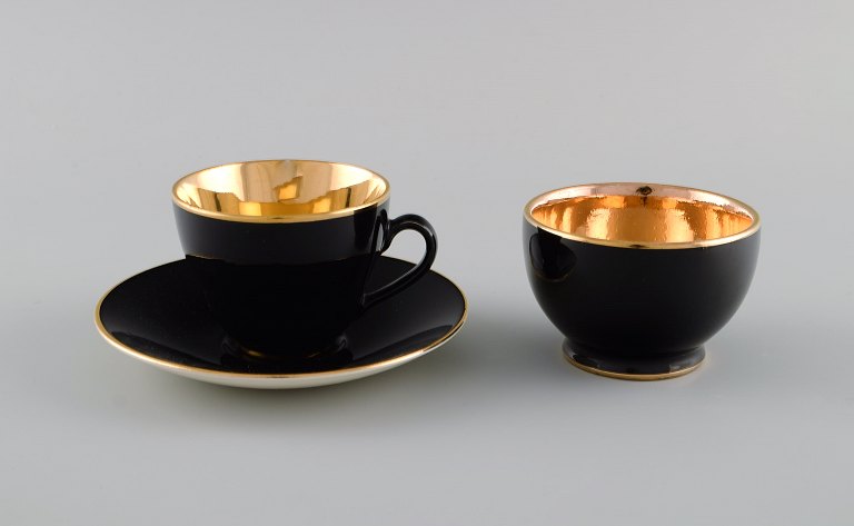 Royal Copenhagen / Aluminia Confetti mocha cup with saucer and sugar bowl in 
black glazed faience with interior gold. Mid-20th century.
