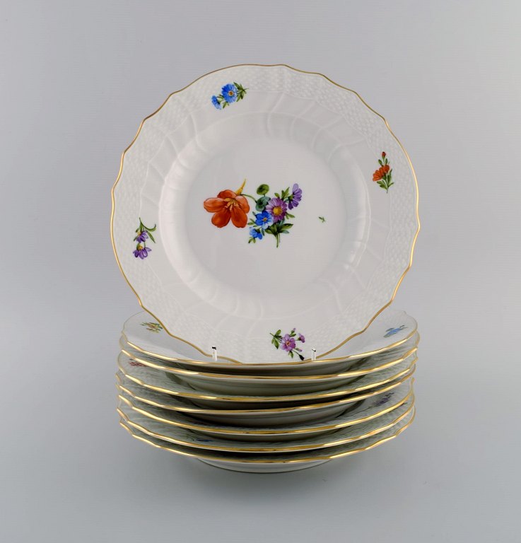 Royal Copenhagen Saxon Flower. Eight dinner plates in hand-painted porcelain 
with flowers and gold decoration. Model number 493/1621. Dated 1953.
