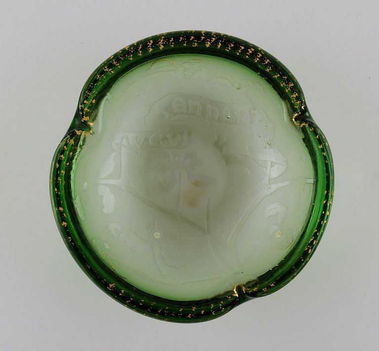 Daum Nancy, France. Art nouveau bowl in green mouth blown art glass. Embossed 
flowers and hand-painted gold decoration. Approx. 1900.
