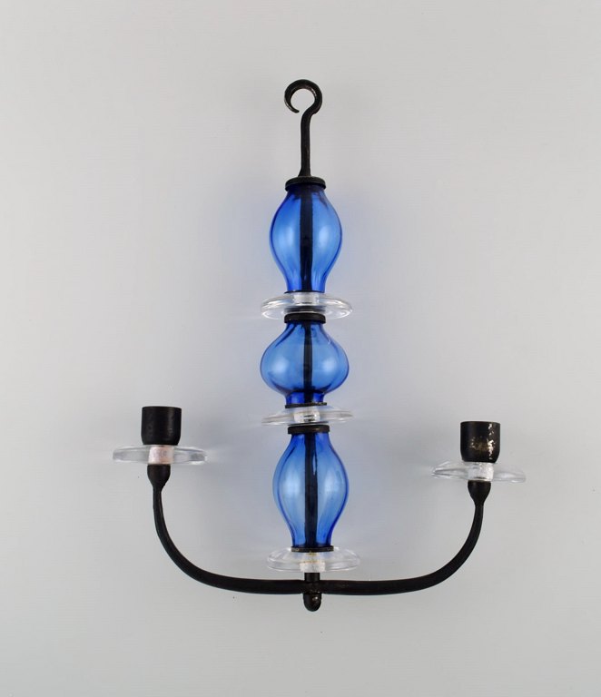 Erik Höglund (1932-1998) for Kosta Boda. Rare two-armed candlestick for hanging 
in cast iron and mouth-blown art glass. Mid-20th century.
