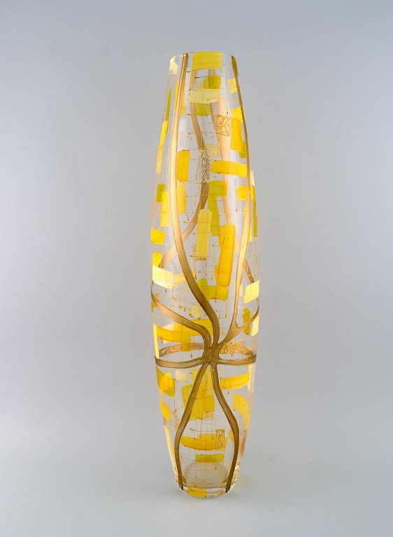 Stor gulvvase i mundblæst kunstglas. Håndmalet geometrisk mønster i guld og gul. 
1960