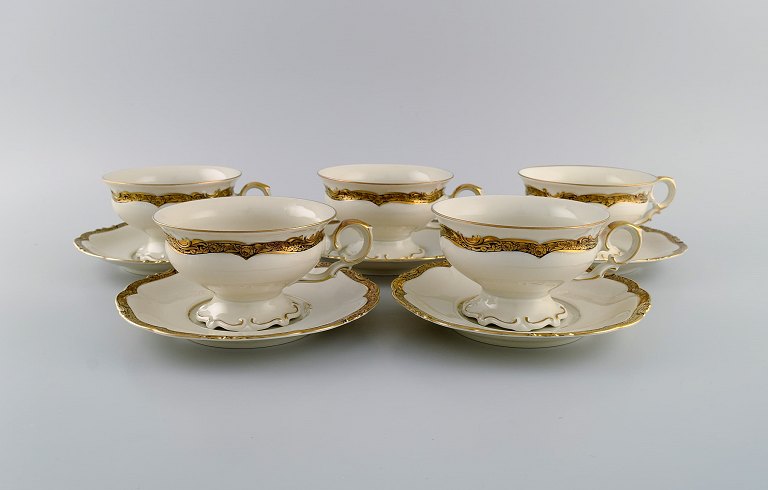 KPM, Berlin. Five Royal Ivory teacups with saucers in cream-colored porcelain 
with gold decoration. 1920s.
