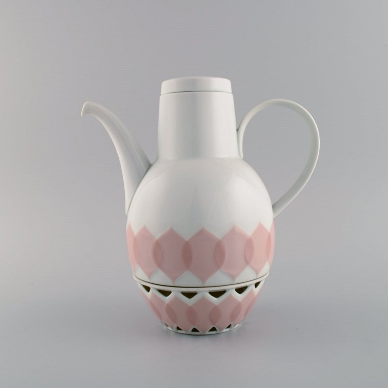 Bjørn Wiinblad for Rosenthal. Lotus porcelain service. Coffee pot with heater 
for tealight candles decorated with pink lotus leaves. 1980s.
