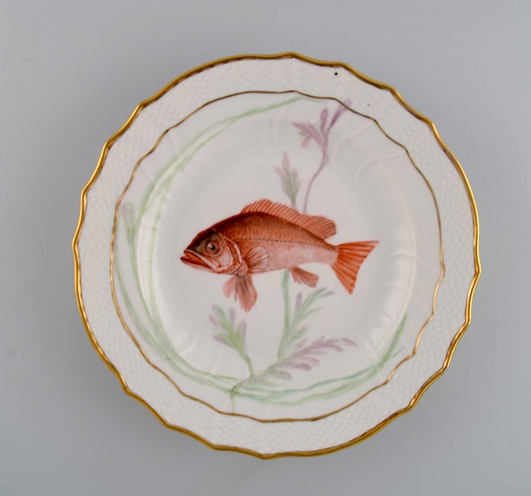 Royal Copenhagen porcelain dinner plate with hand-painted fish motif and golden 
border. Flora / Fauna Danica style. Dated 1951.
