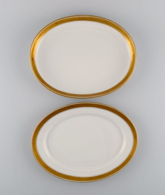 Royal Copenhagen stel nr. 607. To ovale porcelænsfade. Guldkant med bladværk. 
1940