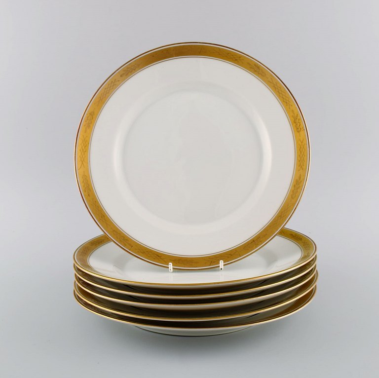Royal Copenhagen service no. 607. Six porcelain dinner plates. Gold border with 
foliage. Model number 607/9586. Dated 1944.
