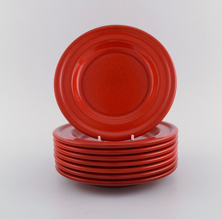 Emile Henry, France. Eight lunch plates in glazed stoneware. Beautiful glaze in 
shades of red. Mid 20th century.
