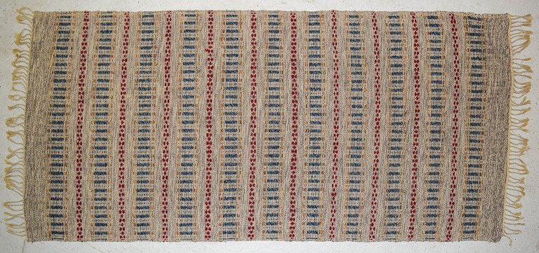 Svensk tekstildesigner, håndvævet tæppe med frynser i uld.
Moderne design med geometrisk mønster.