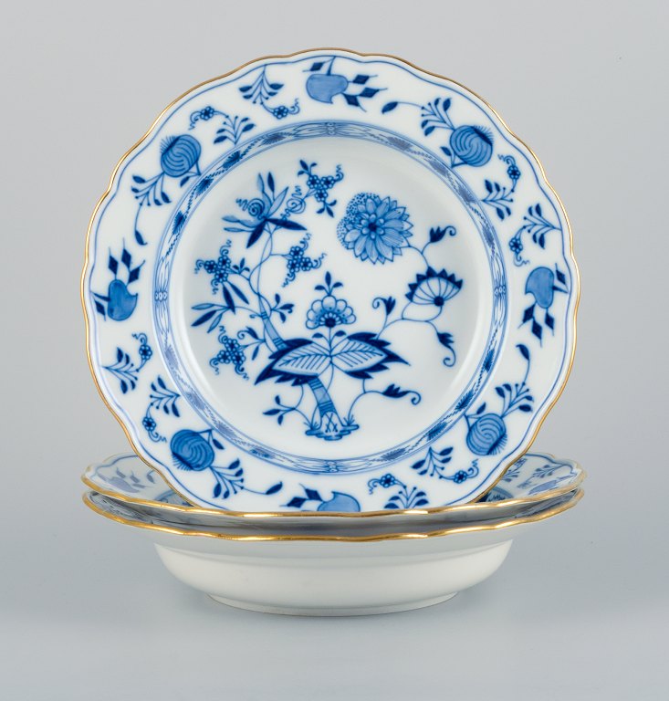 Meissen, Tyskland, et sæt tre dybe tallerkner, løgmønstret porcelænstallerkner 
med guldkant.