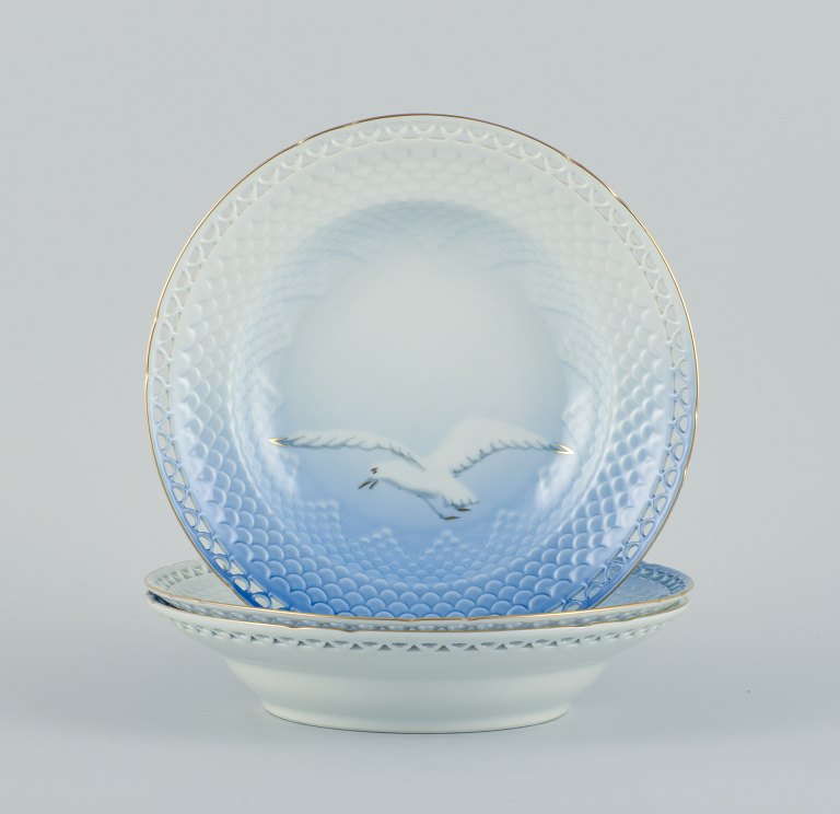 Bing & Grøndahl seagull, three deep plates with reticulated rim and gold 
decoration. Motif with seagull.